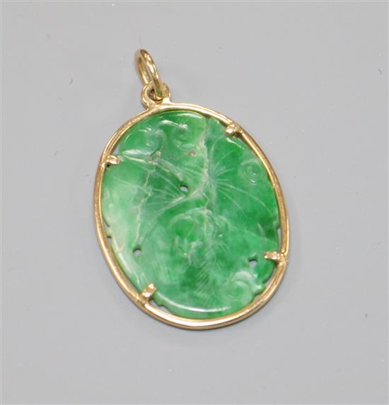 A 14ct gold and carved jadeite set oval pendant, 30mm.